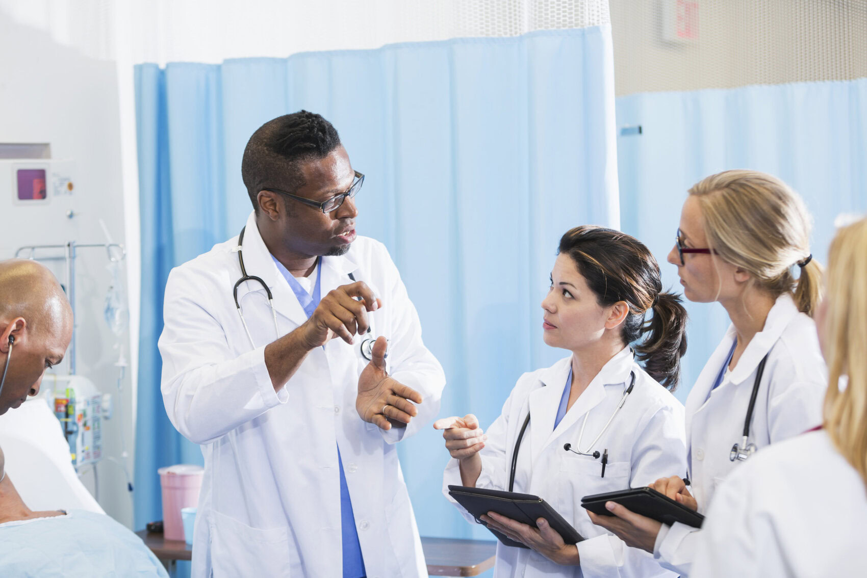 Team of doctors talking in hospital Medical Professionals Talking and Holding Tablets